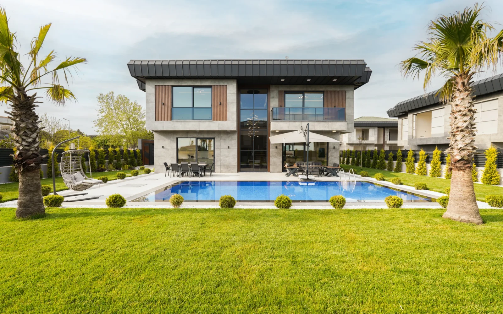 Garden İstanbul villası karşıdan; simetrik cephe, özel havuz ve palmiyeli bahçe — Büyükçekmece, İstanbul