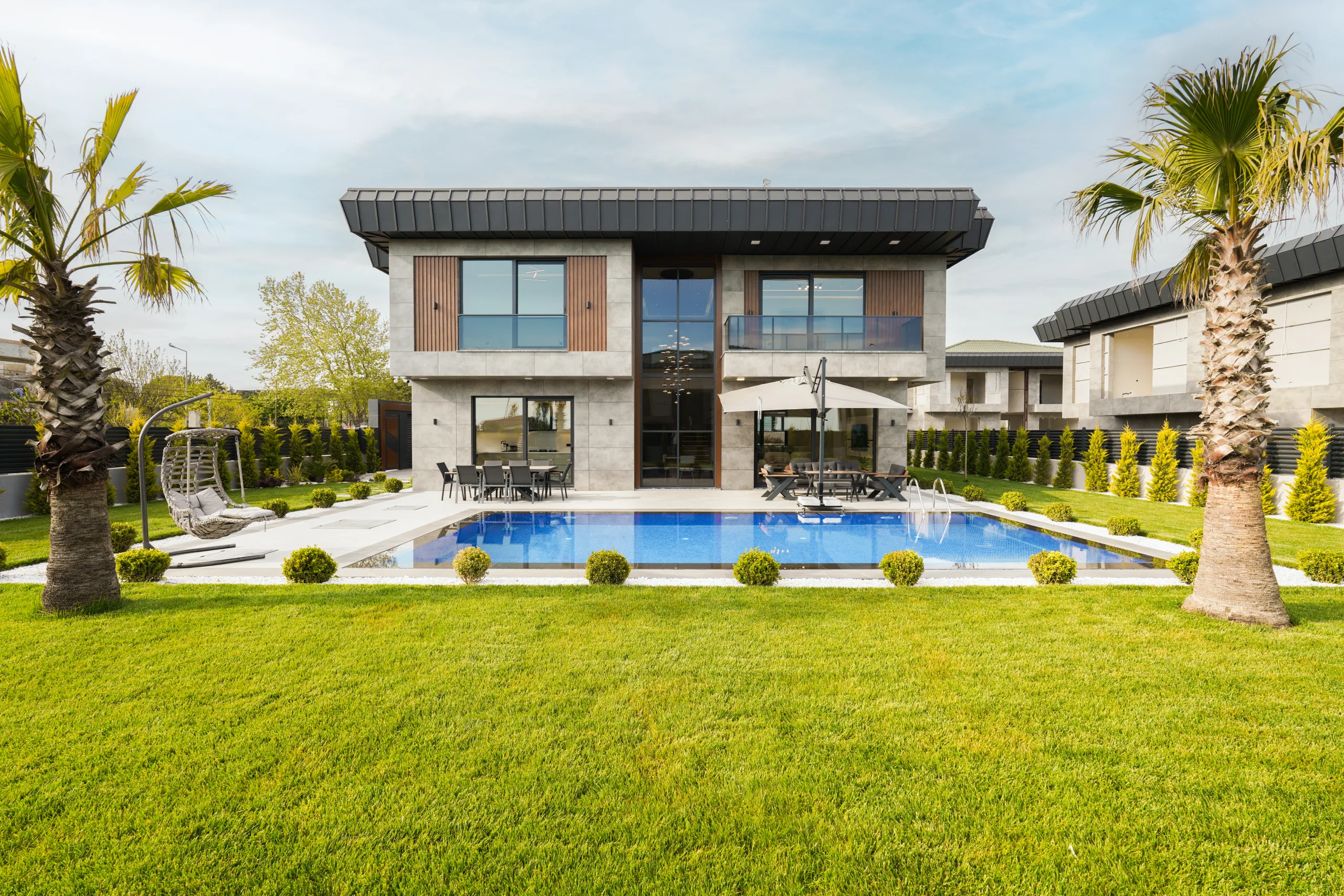 Garden İstanbul villası karşıdan; simetrik cephe, özel havuz ve palmiyeli bahçe — Büyükçekmece, İstanbul