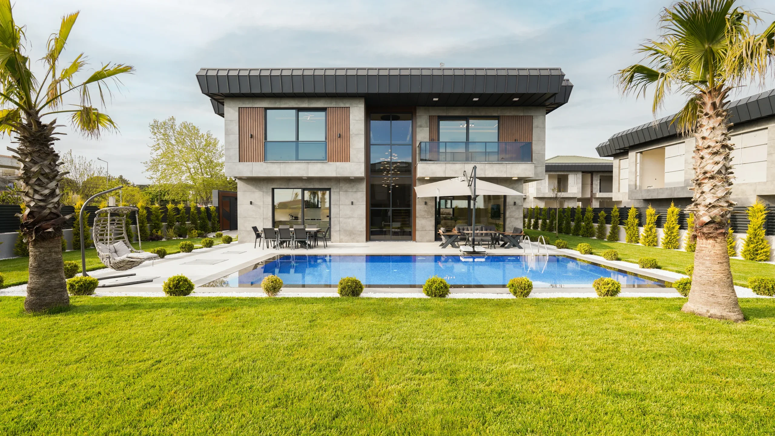 Garden İstanbul müstakil villasının bahçe cephesi, palmiyeli peyzaj ve havuz