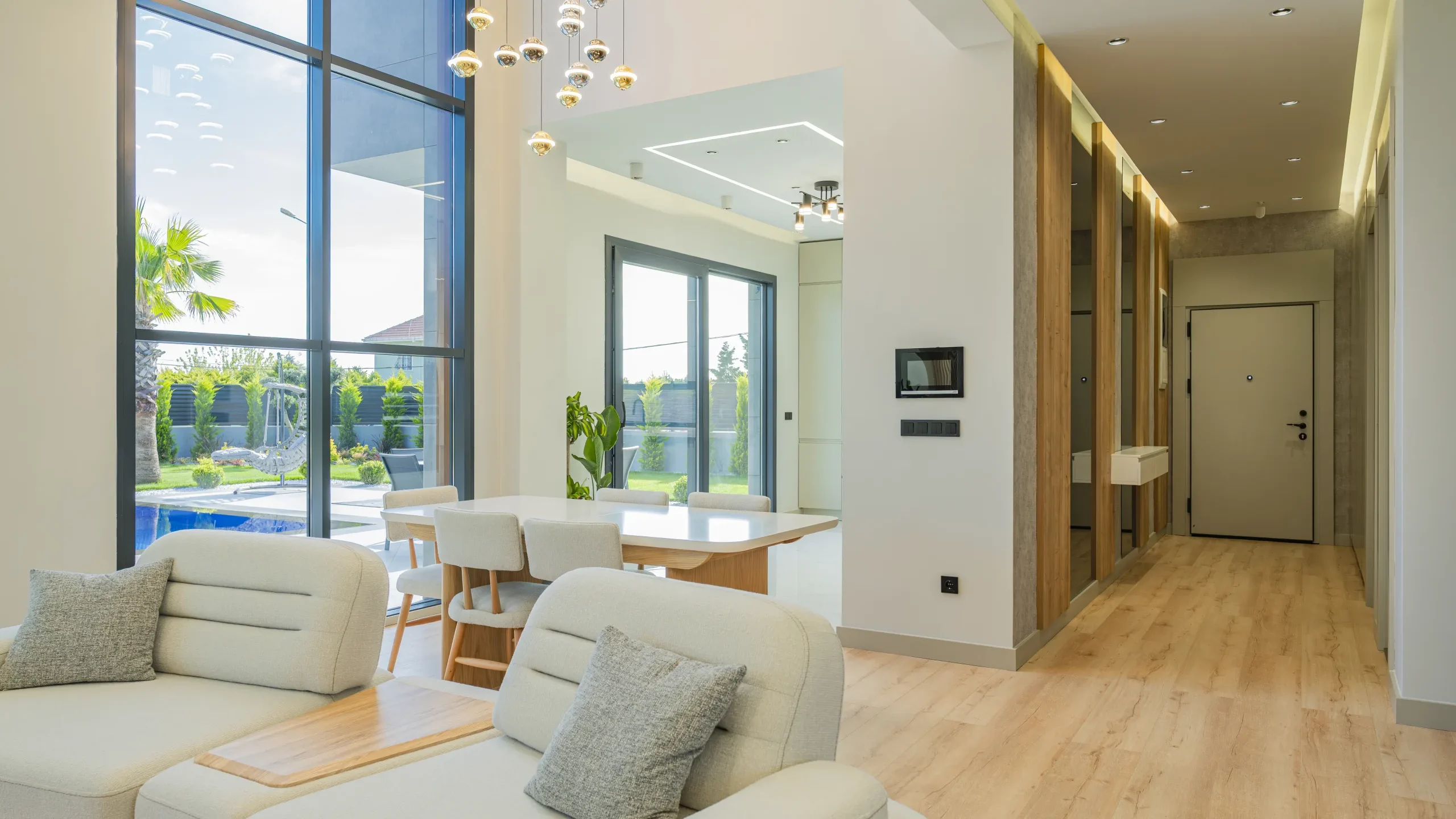 Garden İstanbul villasında çift kat yüksekliğinde salon, geniş cam cephe ve yemek alanı