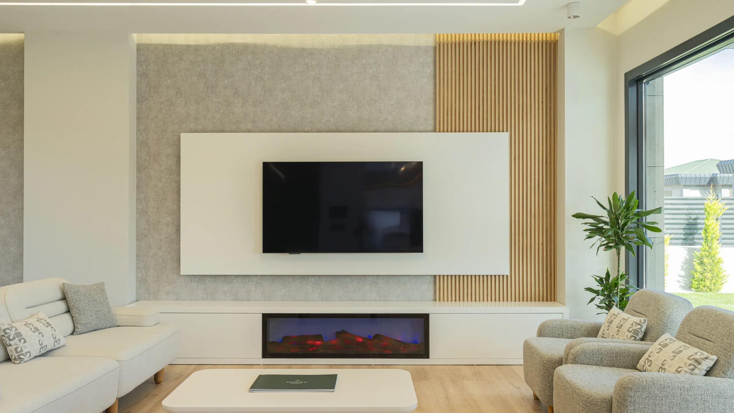 Garden İstanbul villasının oturma odası; ahşap lamel duvar, gömme şömine ve TV ünitesi
